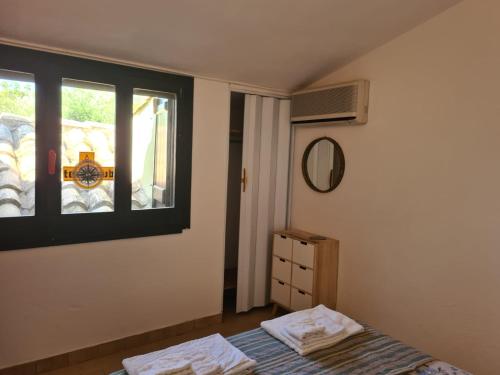 a bedroom with a bed and a window at Villa caposchiera a 500 metri dal mare in Villasimius