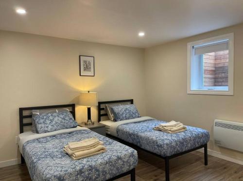 1 dormitorio con 2 camas y ventana en Katie entire basement 3 bedrooms en Charlottetown