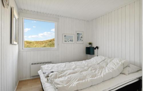 a white bedroom with a large bed with a window at Gorgeous Home In Hvide Sande With Sauna in Havrvig