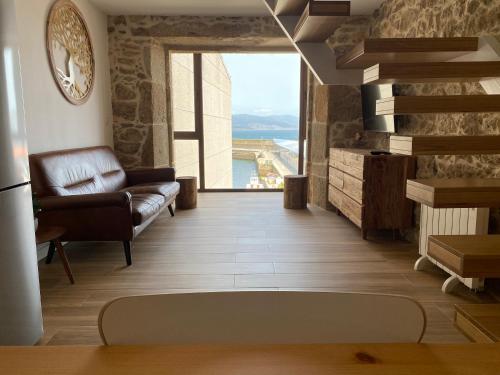 a living room with a couch and a large window at Casa Real 43 in Finisterre