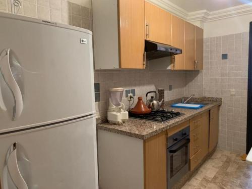 uma cozinha com um frigorífico branco e um fogão em Appartement rez-de-chaussee em Aït Ali