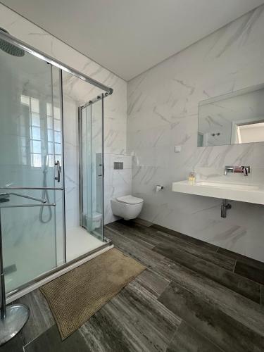 a bathroom with a shower and a toilet and a sink at Casa Branca in Ericeira
