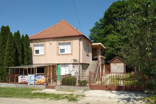 a house with a fence in front of it at Erdei Vendégház in Nagyesztergár