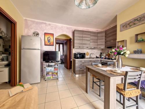 a kitchen with a refrigerator and a table with chairs at Holiday Sun in Badesi