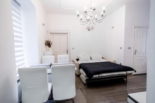 a white room with a bed and a chandelier at Kenti Residence in Ljubljana