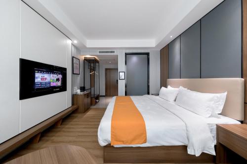 ein Schlafzimmer mit einem großen Bett und einem Flachbild-TV in der Unterkunft Morninginn, Qingyuan Gulong Gorge Wanda Plaza in Qingyuan
