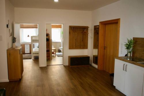 a room with a kitchen and a living room with wooden floors at 3,5 Zimmer Wohnung nahe Legoland in Neuburg an der Kammel