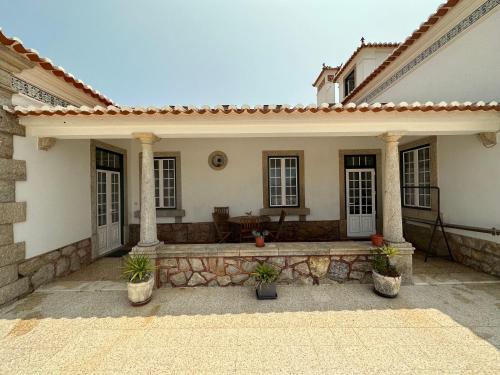 a house with a porch with potted plants at Casa Branca in Ericeira