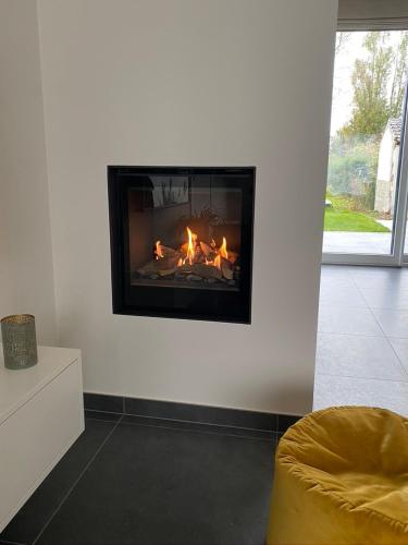 a living room with a fire in the wall at Die huis 14-Een oase van rust tussen polders en kust in Ostend
