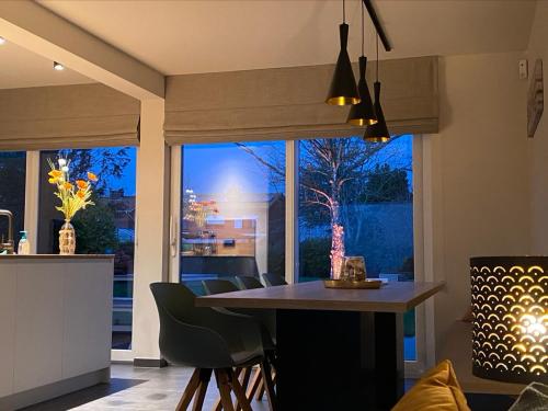 a kitchen with a table and a large window at Die huis 14-Een oase van rust tussen polders en kust in Ostend