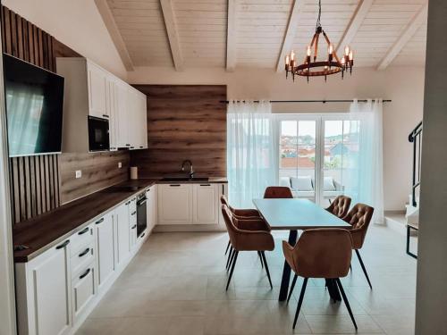 eine Küche mit Tisch und Stühlen und ein Esszimmer in der Unterkunft STONE HOUSE JEZERA in Jezera