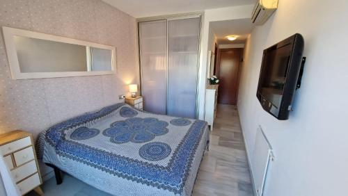een kleine slaapkamer met een bed en een televisie bij Apartamento Denia Elegance Las Marinas in Denia