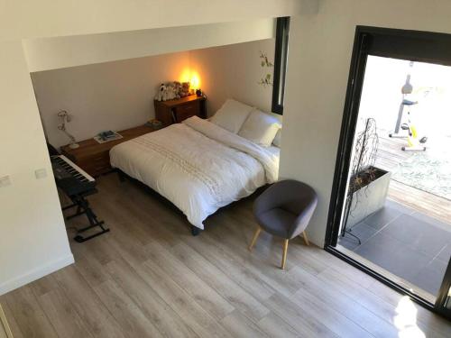 1 dormitorio con 1 cama, 1 silla y 1 ventana en Sunset villa en Cassis