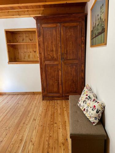 a room with a wooden cabinet and a couch at Relax sul Brembo - Casa Vacanze in Olmo al Brembo