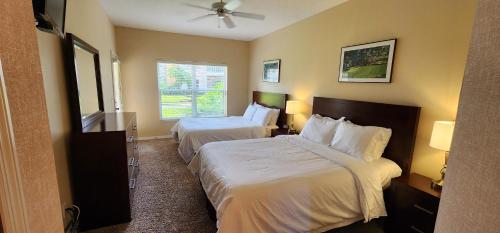 ein Hotelzimmer mit 2 Betten und einem Fenster in der Unterkunft Right Direction Rentals in Port Saint Lucie