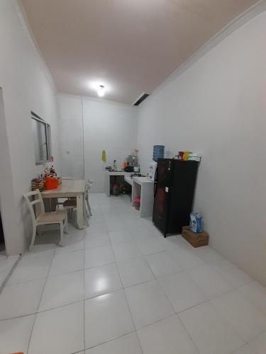 um quarto com uma cozinha com uma mesa e um frigorífico em Bumi Dieng Indah Residence em Kalianget