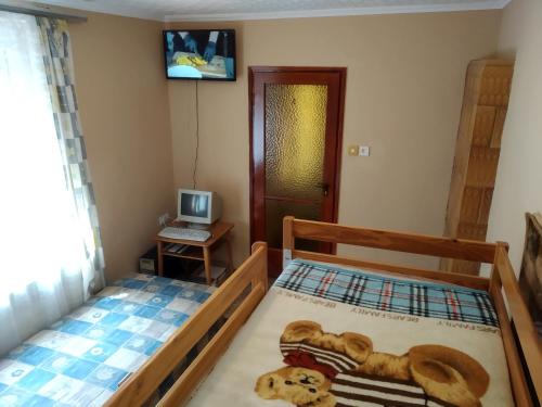 two beds in a room with a computer on a table at Erdei Vendégház in Nagyesztergár