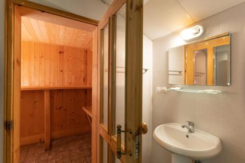 La salle de bains est pourvue d'un lavabo et d'un miroir. dans l'établissement Eco Hotel Imenieto, à Emen