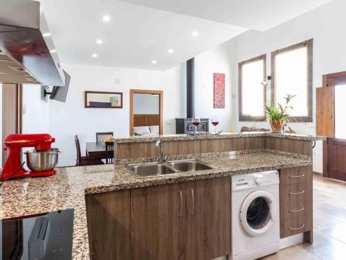 een keuken met een wastafel en een wasmachine bij Casa Puentelata in Dúrcal