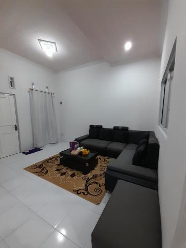a living room with a black couch and a table at Bumi Dieng Indah Residence in Kalianget