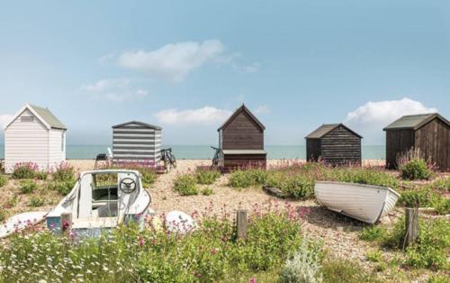 a boat sitting on the beach with houses at STYLISH CHALET with SEA VIEWS at Kingsdown Park with Swimming POOL in Kingsdown