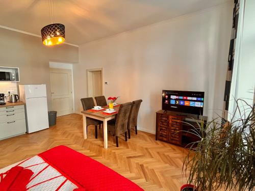 a living room with a table and a television at Riverbridge Apartments Prague in Prague
