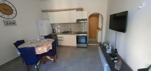 eine kleine Küche mit einem Tisch und einem Fernseher darin in der Unterkunft Blue Sea in Pirovac