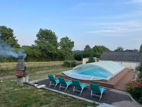 - une grande piscine avec des chaises à côté d'une maison dans l'établissement Les Cèdres Landais, belle maison, à Notre-Dame-des-Landes