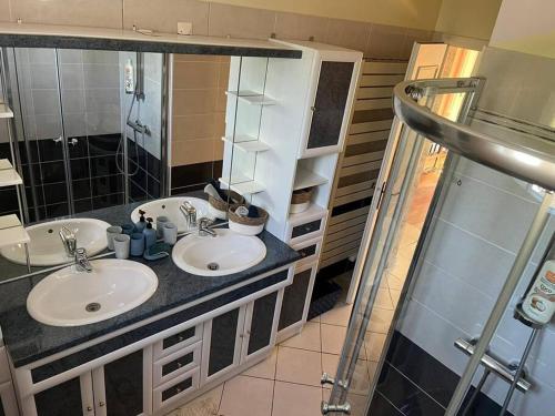 une salle de bain avec deux lavabos et un miroir dans l'établissement Les Cèdres Landais, belle maison, à Notre-Dame-des-Landes