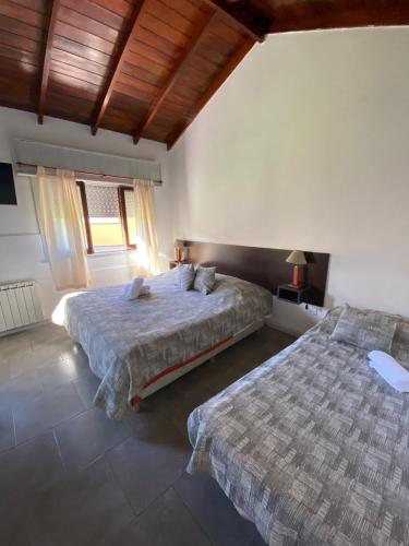ein Schlafzimmer mit zwei Betten und einem Fenster in der Unterkunft Complejo San Cristobal in Santa Clara del Mar