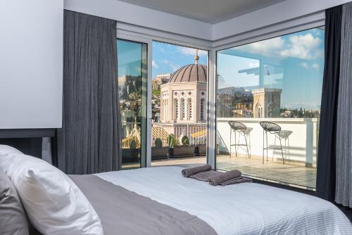 um quarto com uma cama e uma grande janela em Private Loft Suite with stunning view of Acropolis em Atenas