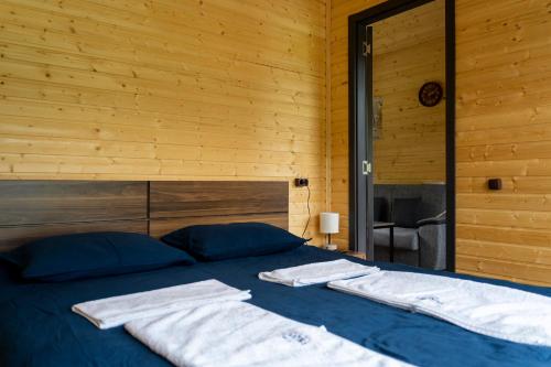 a bedroom with a blue bed with towels on it at Gorai in Kazbegi