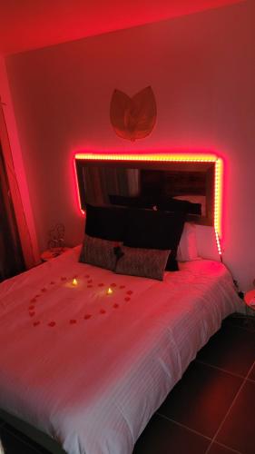 - une chambre avec un lit à éclairage rouge dans l'établissement NiD'Amour l'Hirondelle, à Bézenac