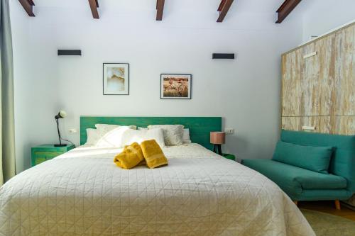 1 dormitorio con 1 cama y 1 silla azul en La Siesta del Naranjo, en Monesterio