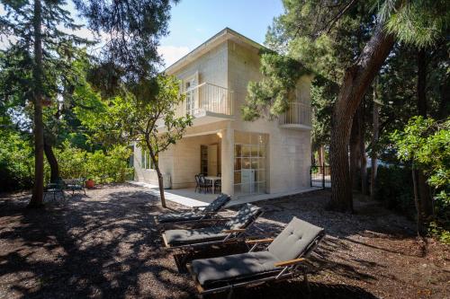 a house with chairs and trees in front of it at Villa Linda in Split