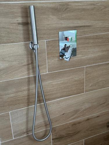 una ducha con una manguera pegada a la pared en CoastAL, en Shëngjin