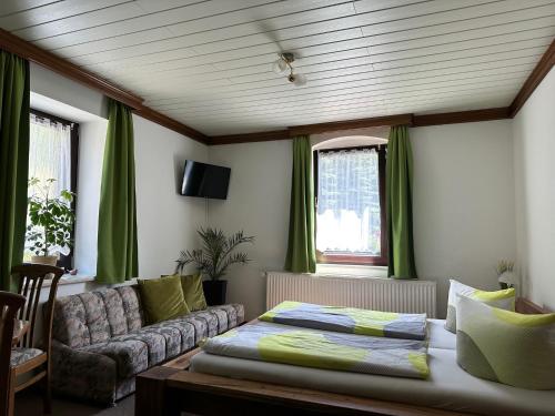 uma sala de estar com uma cama e um sofá em Pension Bennelliebschänke em Seiffen
