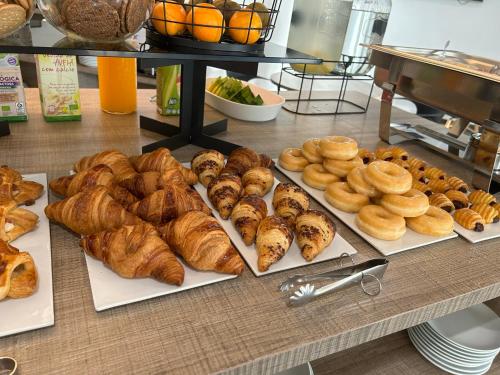 un tavolo con tanti tipi diversi di pane e dolci di Hotel L'Escala Centre a L'Escala