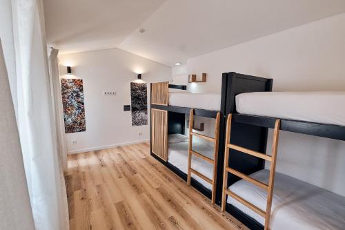 a small room with bunk beds and wooden floors at Volcanic Boutique Hostel in Angra do Heroísmo