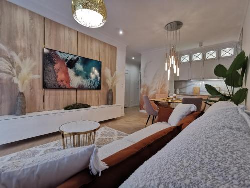 a living room with a couch and a table at Gold Apartment B29 Let's Sea Baltic Park Gąski in Gąski