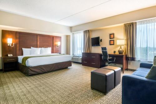 アヴェネルにあるComfort Suites at Woodbridgeの大きなベッドとソファが備わるホテルルームです。
