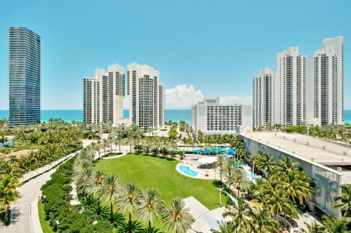 einen Luftblick auf ein Resort mit Palmen und dem Meer in der Unterkunft COLLINS AVE SUNNY VACATION in Sunny Isles Beach