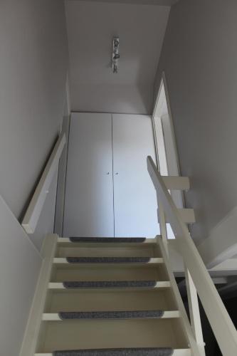 a staircase in a room with a white cabinet at L'Écureuil - Terrasses de Malmedy in Malmedy