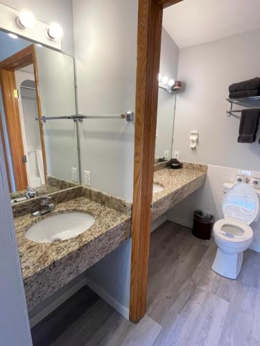 a bathroom with two sinks and a toilet at Lake Bluff Inn and Suites in South Haven