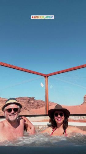 a man and a woman in a hot tub at orbit camp 2 in Wadi Rum