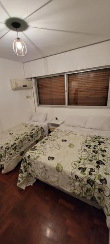 a bedroom with two beds and a ceiling at Beautiful Apt on the Peatonal in Mendoza