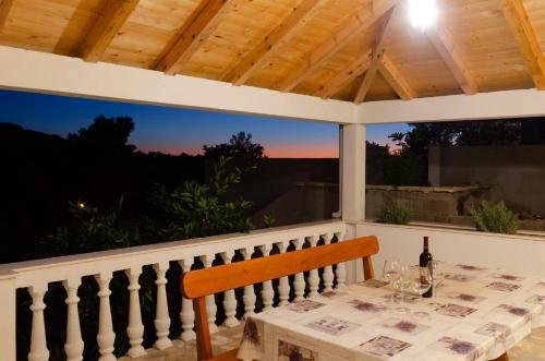 a table with a bottle of wine on a porch at Panoramic Apartments Anić in Blato