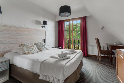 um quarto com uma cama com duas toalhas em Hôtel Le Romantica em Pennedepie