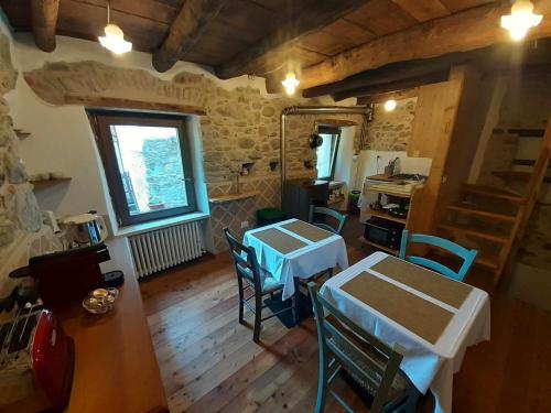 uma cozinha com duas mesas e cadeiras num quarto em La Casa Torre em Pignone