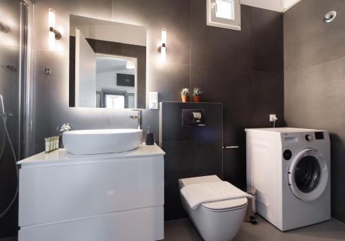 a bathroom with a sink and a washing machine at Villa Nika in Palaiokhóri